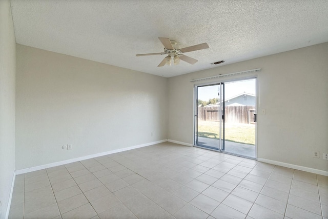 tiled spare room with a textured ceiling and ceiling fan