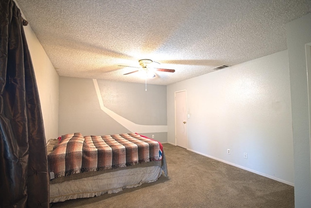 bedroom with ceiling fan, carpet floors, and a textured ceiling