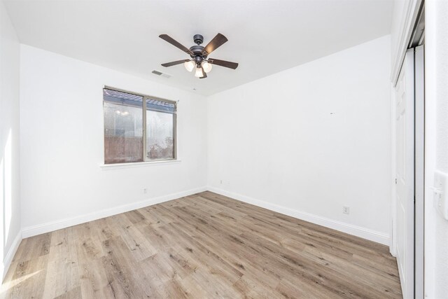 unfurnished bedroom featuring ceiling fan, a closet, and light wood-type flooring