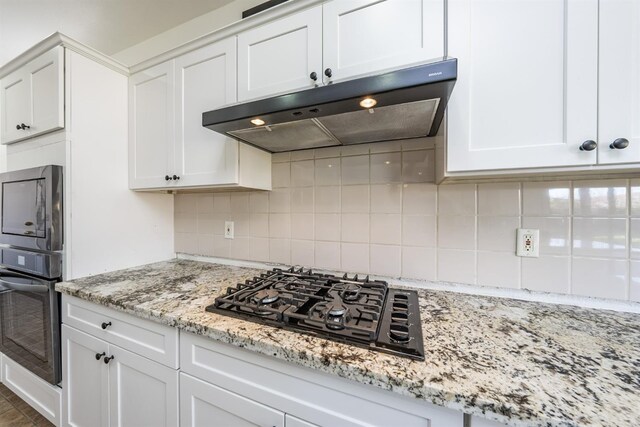 kitchen featuring wall oven, tasteful backsplash, white cabinetry, and black gas stovetop