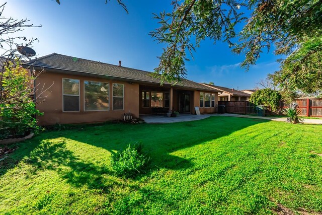 back of property featuring a yard and a patio