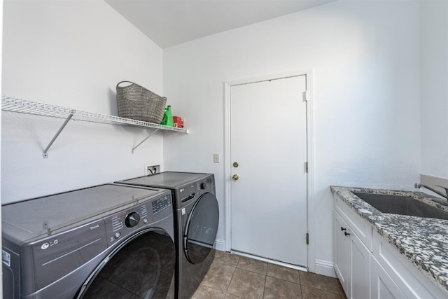 laundry area with cabinets, light tile patterned flooring, washing machine and dryer, and sink