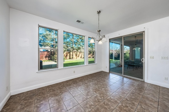 unfurnished dining area featuring a chandelier and dark tile patterned flooring