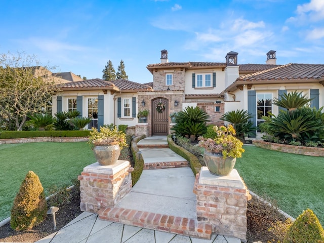 mediterranean / spanish home with a front yard