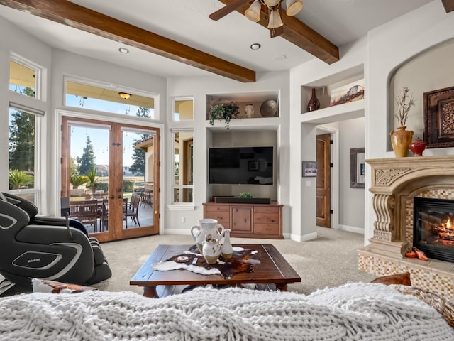 living room with french doors, light colored carpet, ceiling fan, built in features, and a fireplace