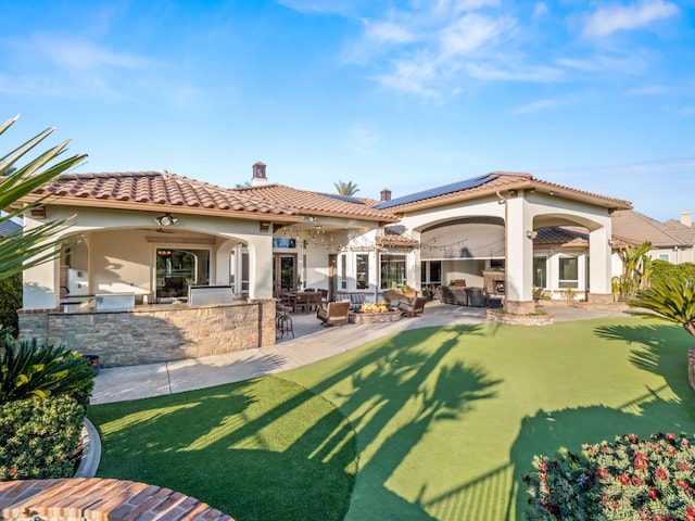 back of house with outdoor lounge area, an outdoor bar, ceiling fan, area for grilling, and a patio