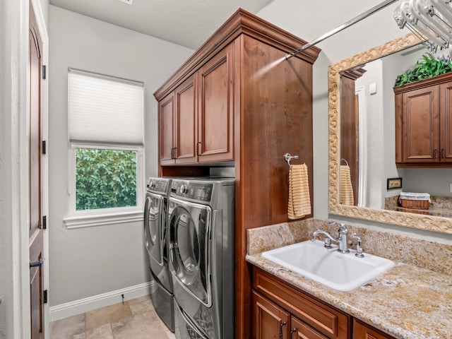 laundry room with washing machine and clothes dryer, sink, and cabinets