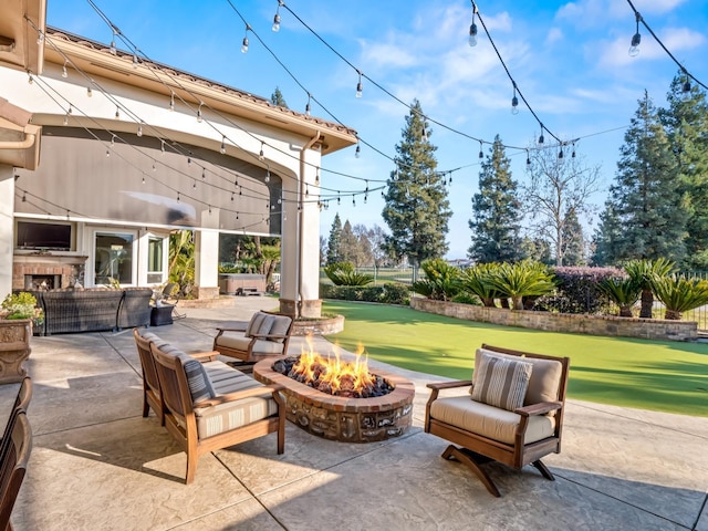 view of patio with an outdoor living space with a fire pit