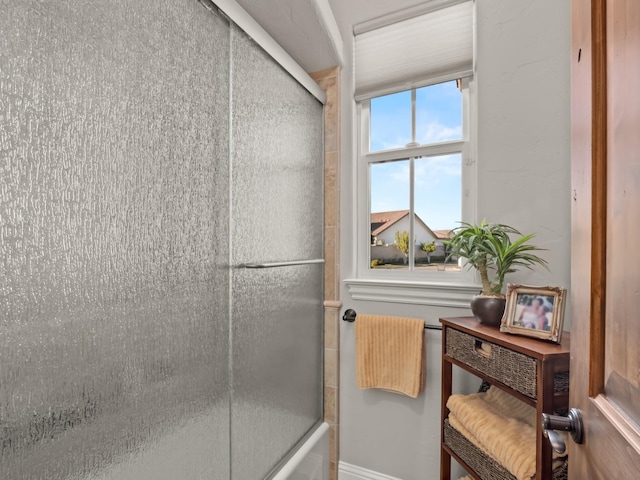 bathroom with combined bath / shower with glass door