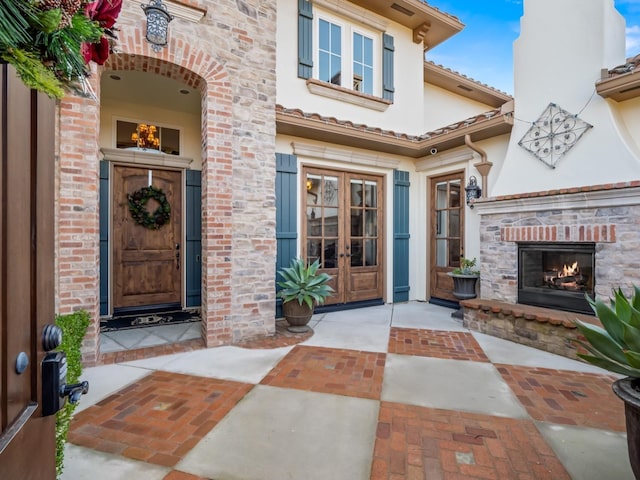 property entrance featuring french doors and exterior fireplace