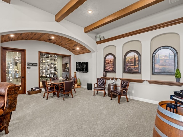 carpeted dining area featuring beam ceiling