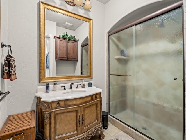 bathroom with vanity and a shower with shower door