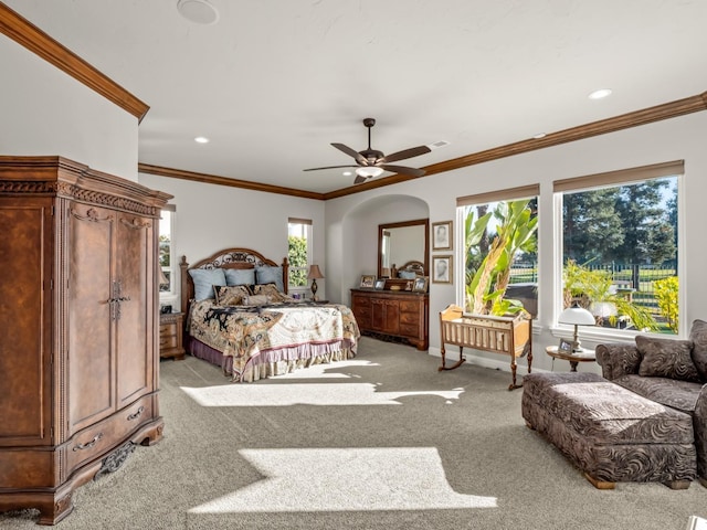 bedroom featuring multiple windows, light colored carpet, ceiling fan, and ornamental molding