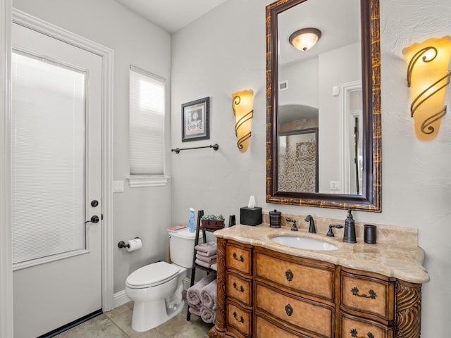 bathroom featuring tile patterned floors, vanity, and toilet