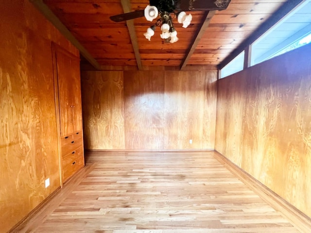 interior space featuring wood walls, wood ceiling, beam ceiling, and light hardwood / wood-style flooring