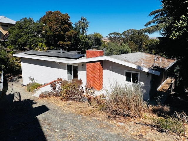 back of property featuring solar panels