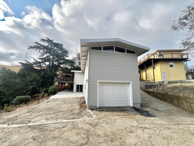 view of property exterior with a garage and a wooden deck