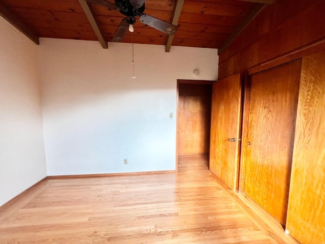 unfurnished room featuring ceiling fan, vaulted ceiling with beams, wood ceiling, and light wood-type flooring