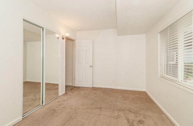 unfurnished bedroom featuring carpet and a closet