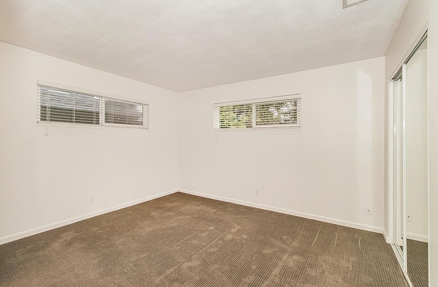 carpeted spare room featuring a textured ceiling