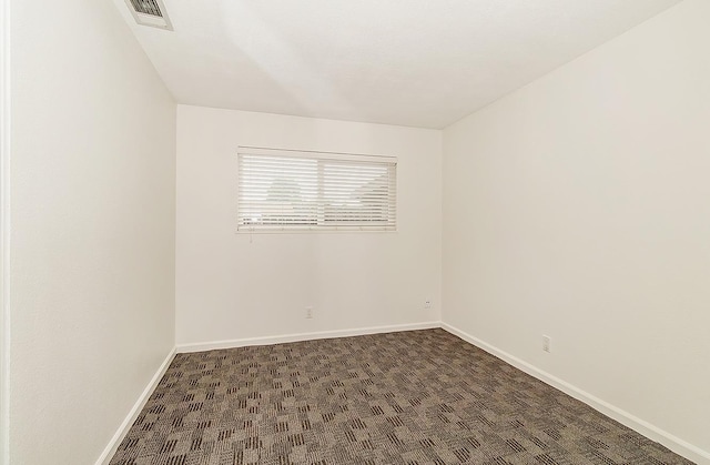 empty room with dark colored carpet