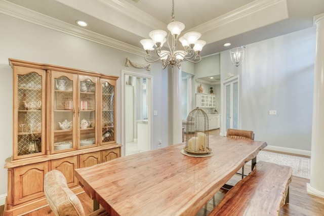 dining area featuring hardwood / wood-style floors, crown molding, and an inviting chandelier