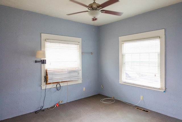 unfurnished room with carpet floors, a wealth of natural light, and ceiling fan