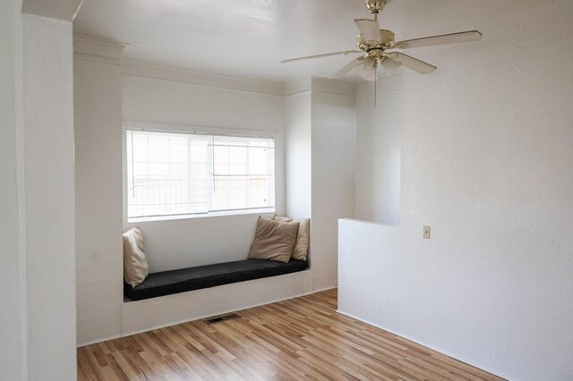 living area featuring light hardwood / wood-style floors, ceiling fan, and ornamental molding