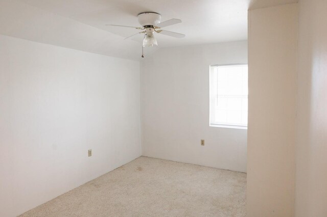 spare room featuring ceiling fan and light carpet