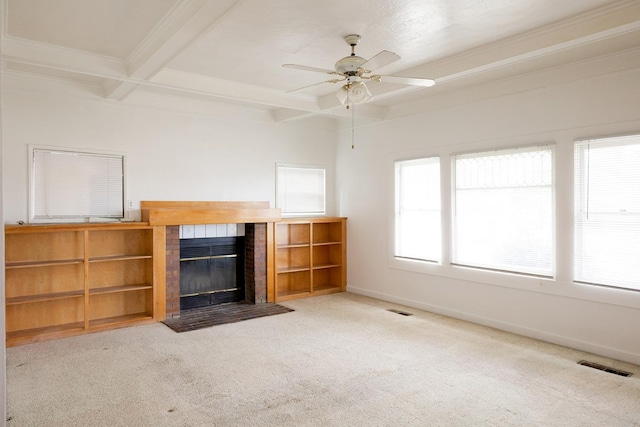 unfurnished living room featuring carpet, plenty of natural light, beam ceiling, and a brick fireplace