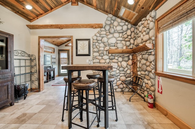 dining area featuring vaulted ceiling with beams, a healthy amount of sunlight, and wooden ceiling