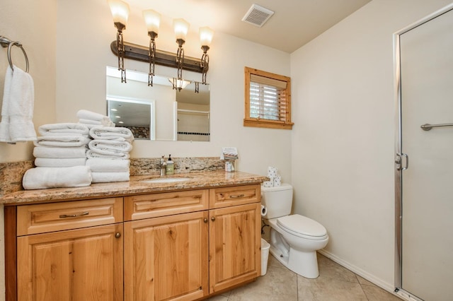 bathroom featuring tile patterned floors, vanity, an enclosed shower, and toilet