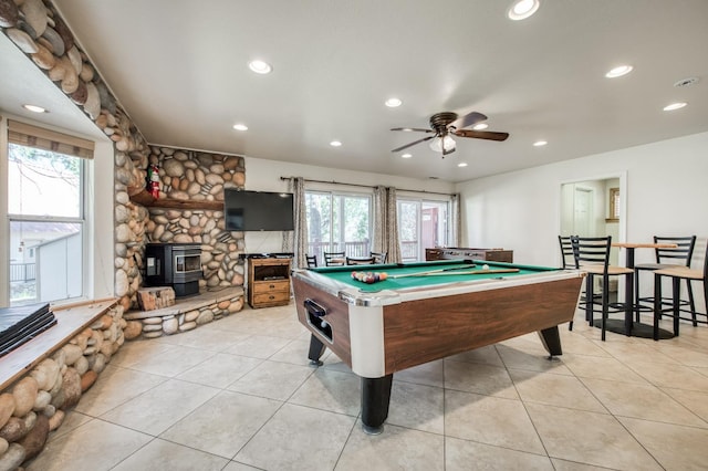 recreation room featuring a wealth of natural light, a wood stove, ceiling fan, and billiards