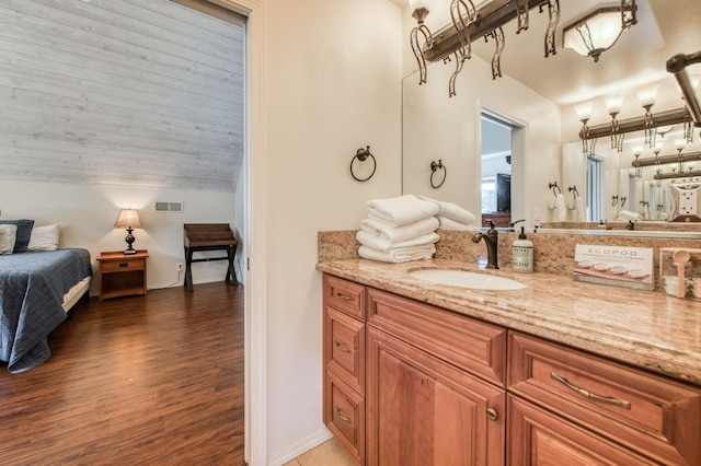 39722 Crest Point Ln, Shaver Lake, CA 93664 - ensuite bathroom with vanity, wood finished floors, vaulted ceiling, and baseboards