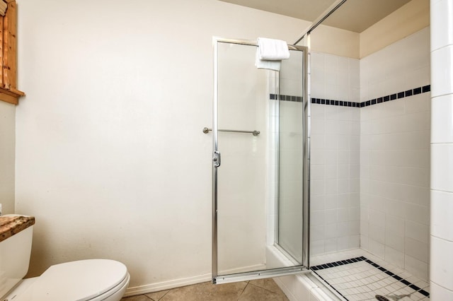 bathroom with tile patterned floors, an enclosed shower, and toilet