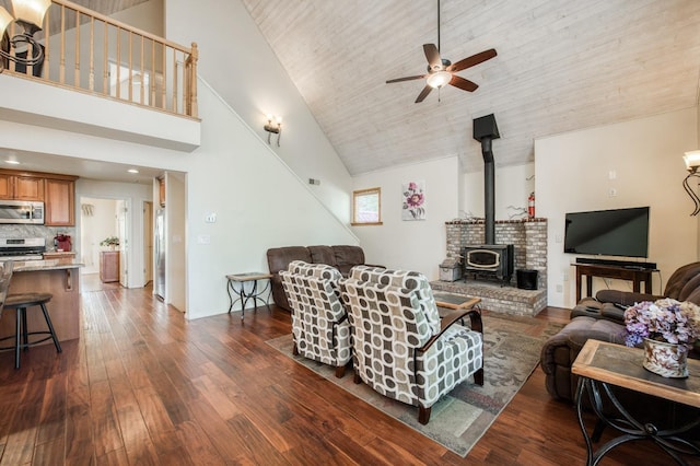 living room featuring wood ceiling, ceiling fan, high vaulted ceiling, dark hardwood / wood-style floors, and a wood stove