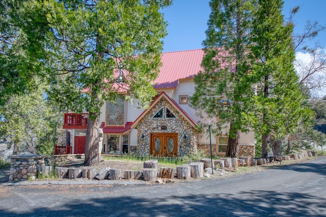 39722 Crest Point Ln, Shaver Lake, CA 93664 - view of front of property featuring stone siding, a balcony, and metal roof