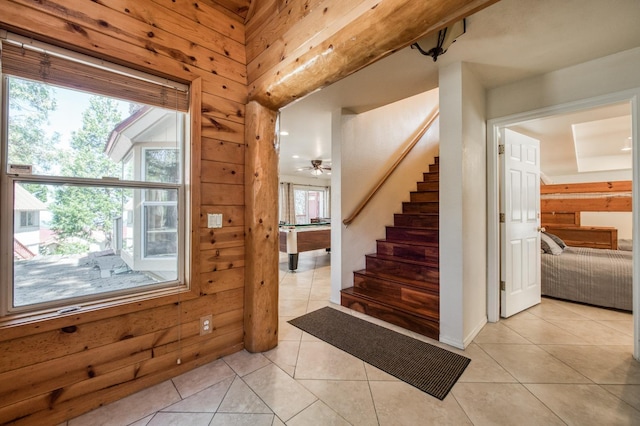 tiled entryway featuring pool table, ceiling fan, and wood walls