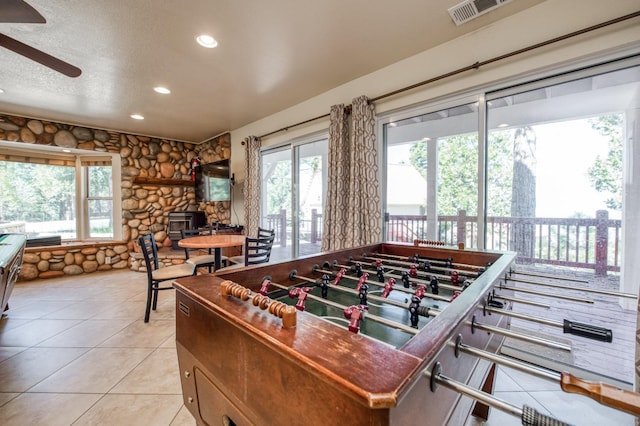 recreation room featuring ceiling fan, light tile patterned floors, and a textured ceiling