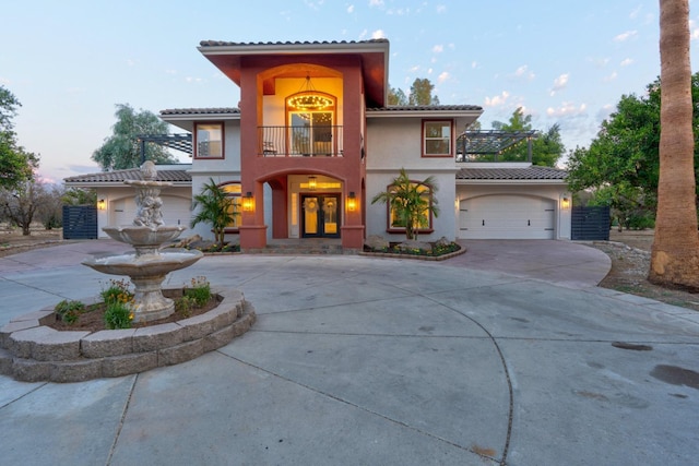 mediterranean / spanish house featuring a garage and a balcony