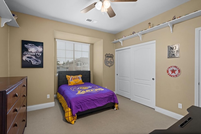 carpeted bedroom featuring ceiling fan and a closet