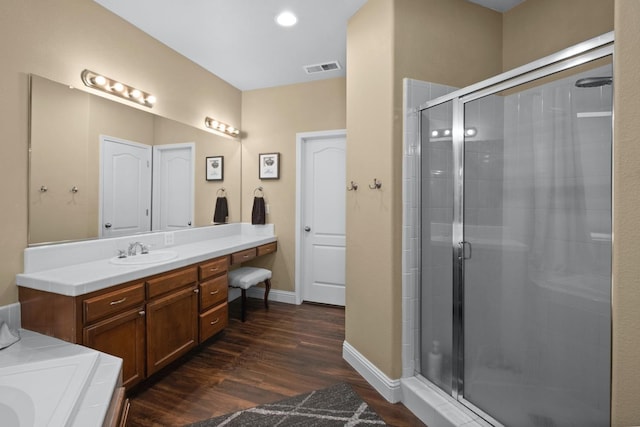 bathroom featuring hardwood / wood-style flooring, vanity, and separate shower and tub