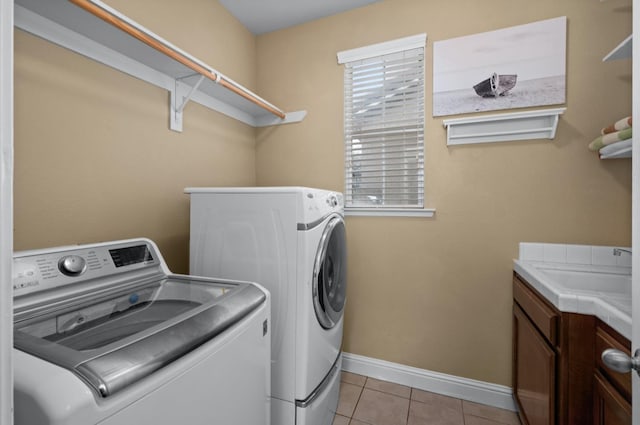 laundry room featuring washer and clothes dryer, light tile patterned floors, cabinets, and sink