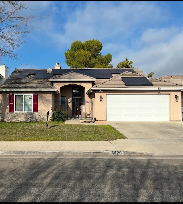 ranch-style house featuring a garage and a front lawn