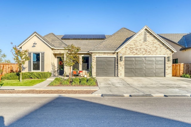 view of front of property featuring solar panels and a garage