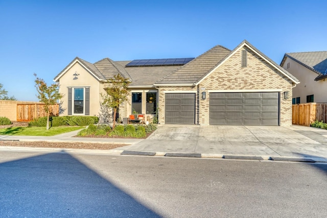 view of front facade with solar panels and a garage