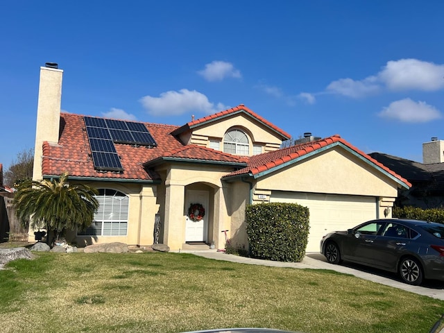 mediterranean / spanish-style house with a garage, a front yard, and solar panels