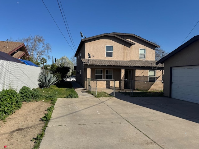 view of front of property featuring a garage, fence, concrete driveway, and stucco siding