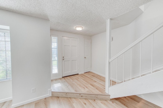 foyer entrance featuring wood-type flooring and a textured ceiling