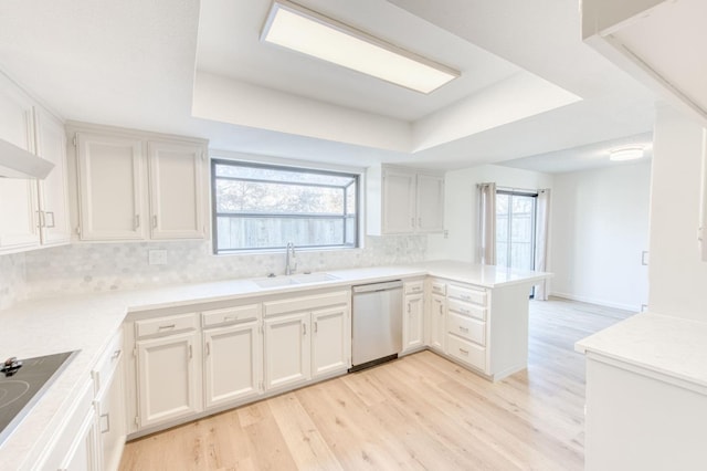 kitchen with kitchen peninsula, a raised ceiling, sink, dishwasher, and white cabinetry